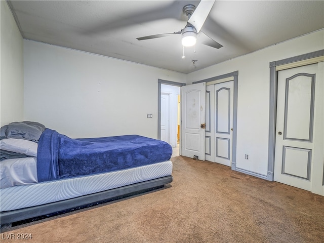 carpeted bedroom featuring a closet and ceiling fan