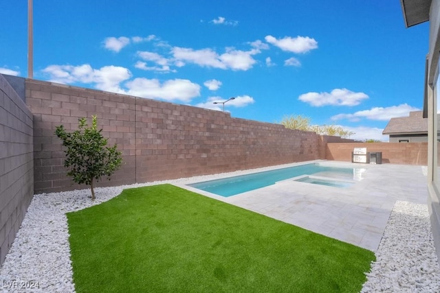 view of pool featuring a patio area, an in ground hot tub, and a lawn