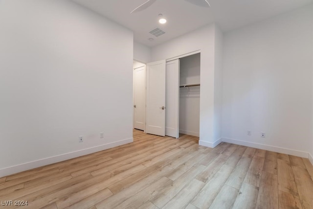 unfurnished bedroom featuring a closet, light wood-type flooring, and ceiling fan