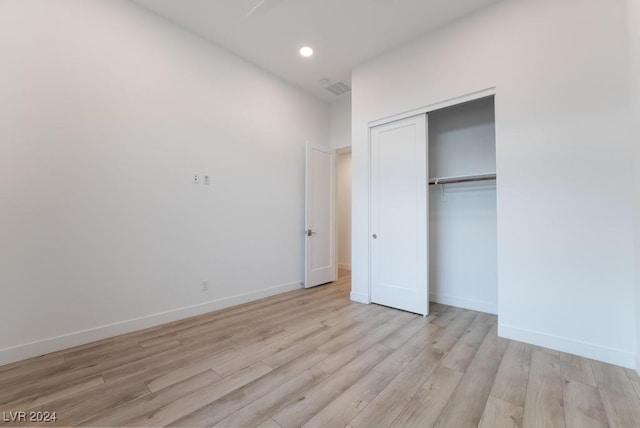 unfurnished bedroom with a closet and light wood-type flooring