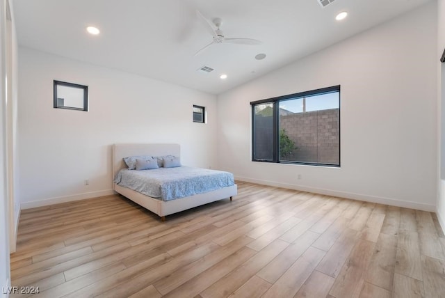 bedroom with vaulted ceiling, light wood-type flooring, and ceiling fan