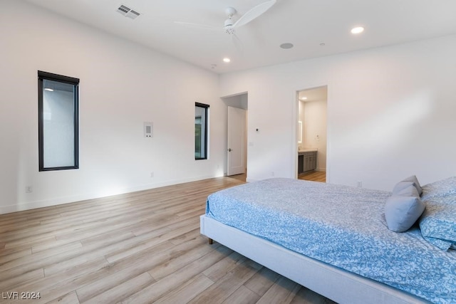 bedroom featuring light hardwood / wood-style flooring, connected bathroom, and ceiling fan