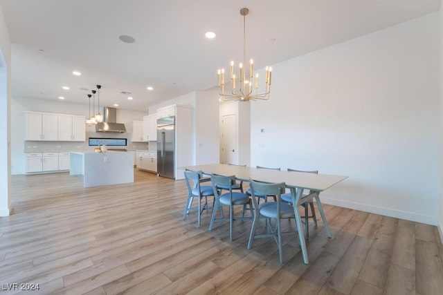 dining space with light hardwood / wood-style flooring and a notable chandelier