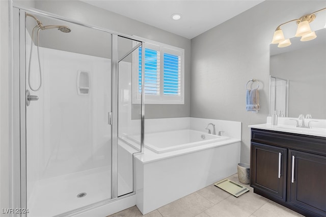 bathroom with tile patterned floors, vanity, and shower with separate bathtub