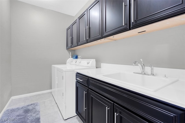 laundry room featuring cabinets, light tile patterned flooring, washer and clothes dryer, and sink