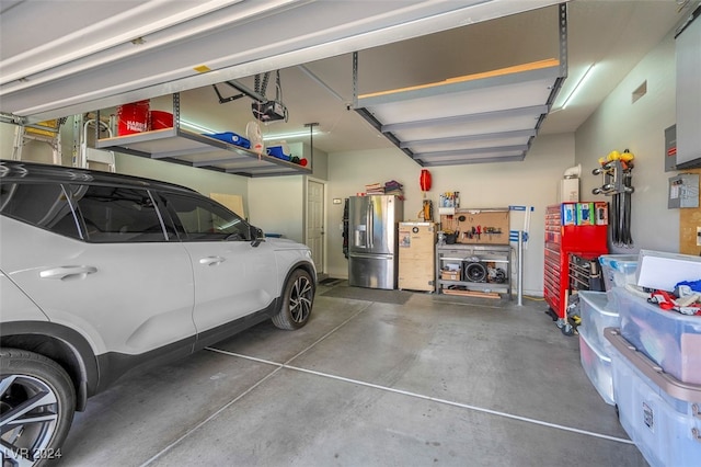 garage with stainless steel fridge and a garage door opener