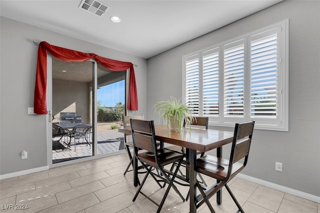 dining space with light tile patterned floors and a healthy amount of sunlight