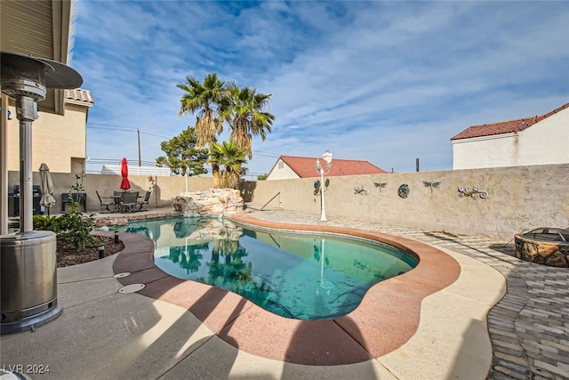 view of swimming pool featuring a patio area and an outdoor fire pit