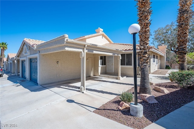 2259 Rugged Mesa Dr, Laughlin, NV 89029 - view of front facade with a tile roof, stucco siding, a chimney, and a garage