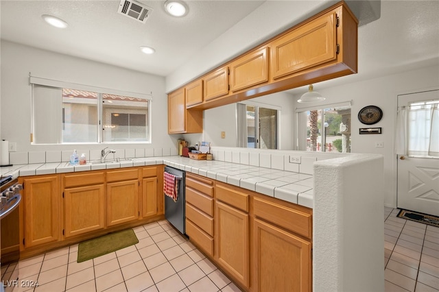 kitchen featuring sink, dishwasher, tile counters, and light tile patterned floors