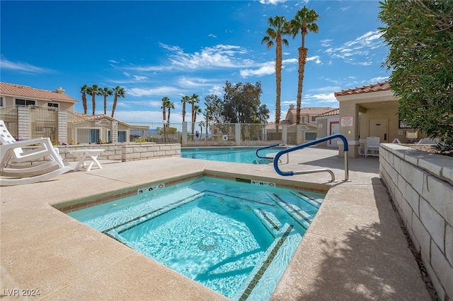 view of pool with a hot tub and a patio area