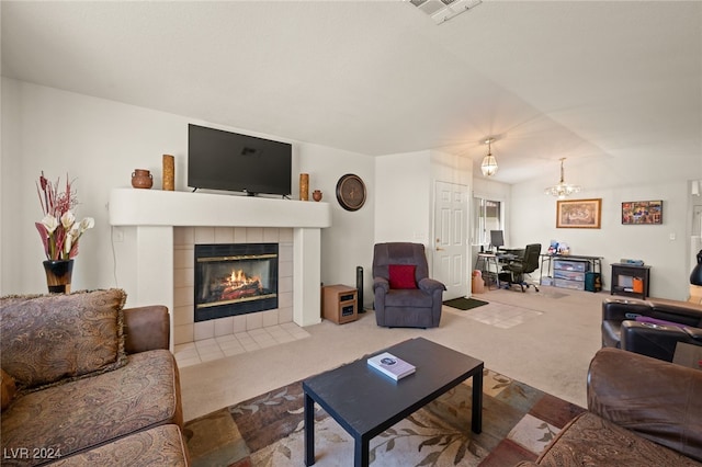 carpeted living room featuring an inviting chandelier and a tile fireplace