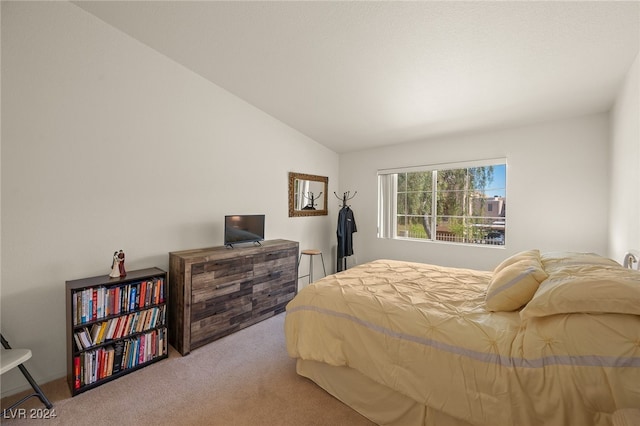 bedroom featuring light carpet and lofted ceiling