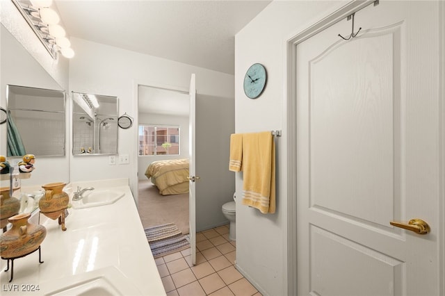 bathroom with toilet, vanity, and tile patterned floors