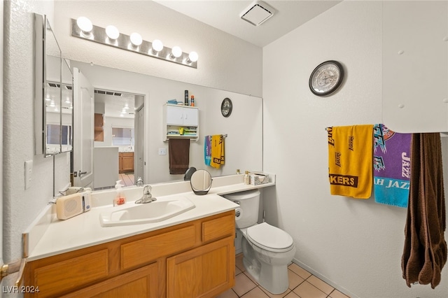 bathroom featuring vanity, toilet, and tile patterned flooring