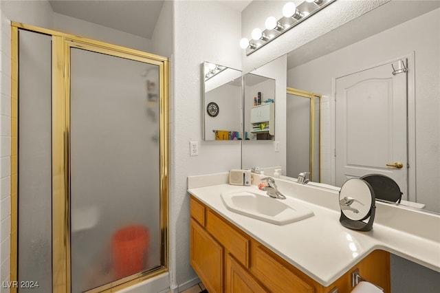 bathroom with a shower with door and vanity