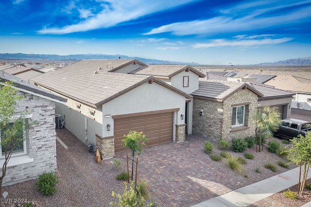 view of front facade featuring central air condition unit, a mountain view, and a garage