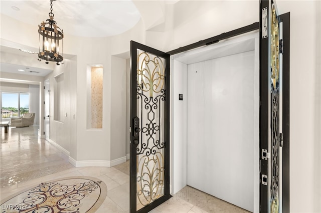 tiled entryway featuring a notable chandelier and a barn door