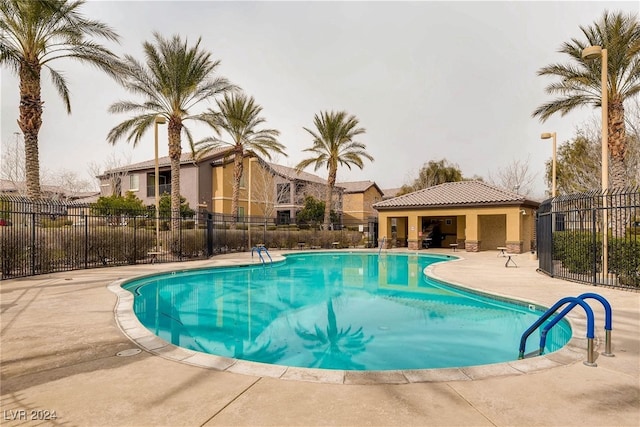 community pool with fence and a patio