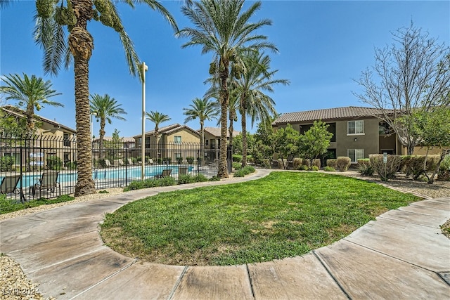 view of property with fence and a community pool