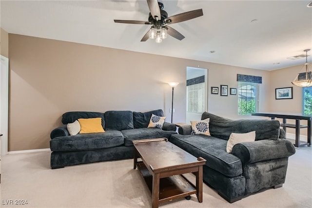 living room featuring light carpet, a ceiling fan, visible vents, and baseboards