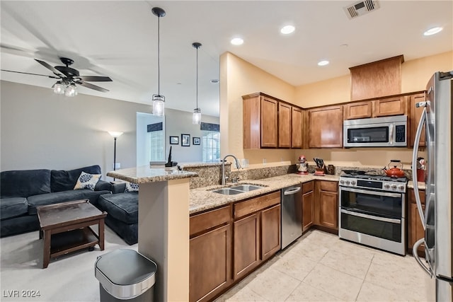 kitchen with pendant lighting, brown cabinets, visible vents, appliances with stainless steel finishes, and open floor plan