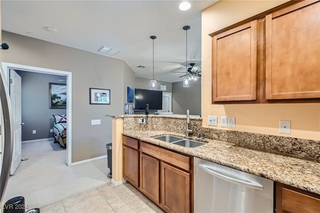 kitchen with a sink, light stone counters, brown cabinetry, and dishwasher