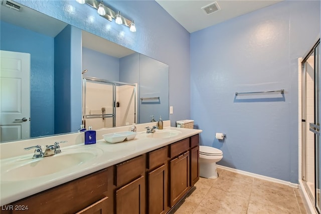 full bathroom featuring double vanity, a shower stall, visible vents, and a sink