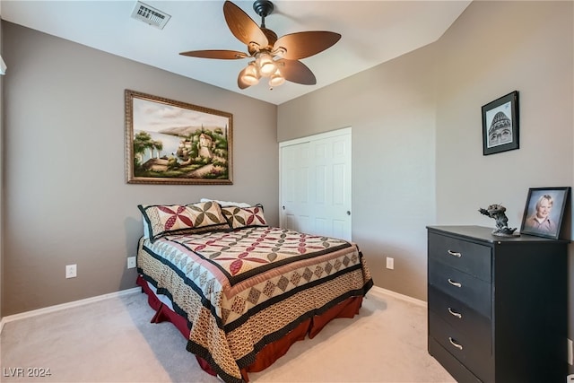 bedroom with a closet, light colored carpet, visible vents, a ceiling fan, and baseboards