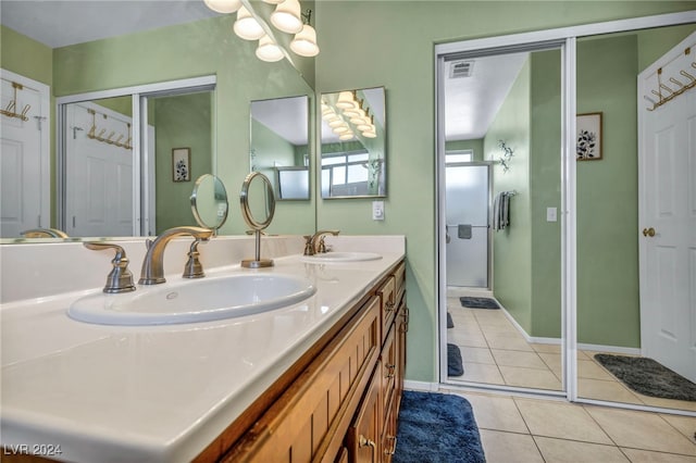 bathroom featuring tile patterned flooring, vanity, and an enclosed shower