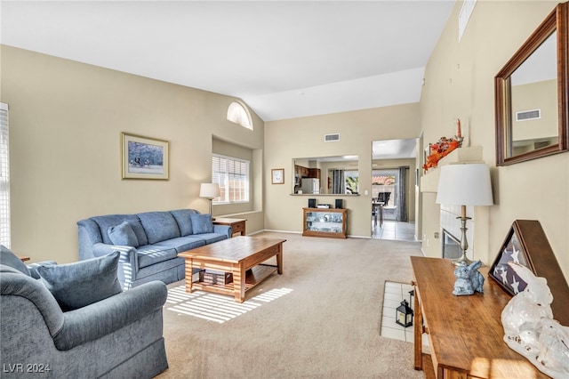 living room featuring light colored carpet and vaulted ceiling