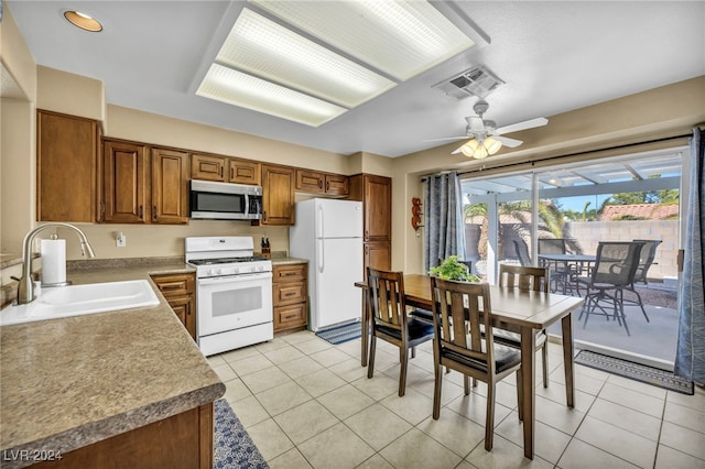 kitchen featuring light tile patterned flooring, white appliances, ceiling fan, and sink