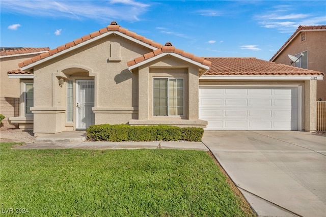 mediterranean / spanish house featuring a garage and a front lawn