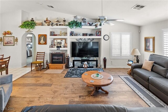 living room with ceiling fan, hardwood / wood-style floors, and vaulted ceiling