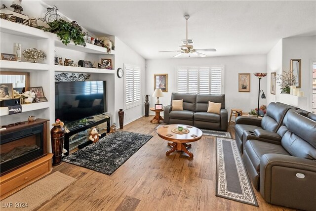 living room with lofted ceiling, ceiling fan, and light wood-type flooring