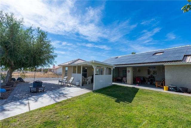 back of house with a lawn, solar panels, and a patio area