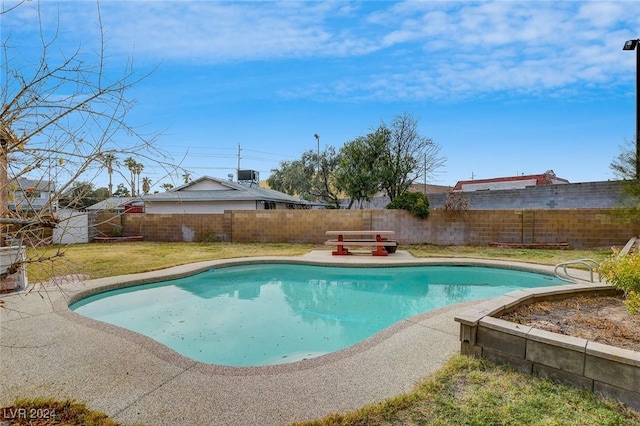 view of pool with a patio and a lawn