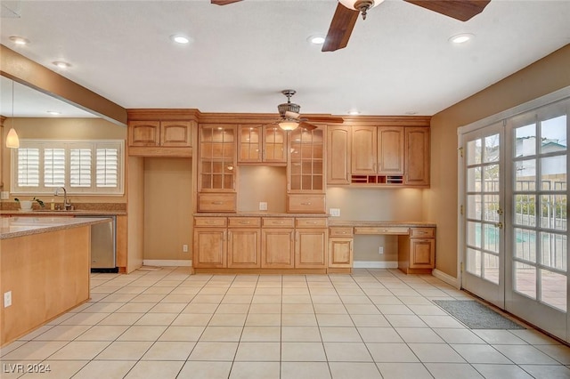 kitchen featuring dishwasher, light stone countertops, decorative light fixtures, and a wealth of natural light