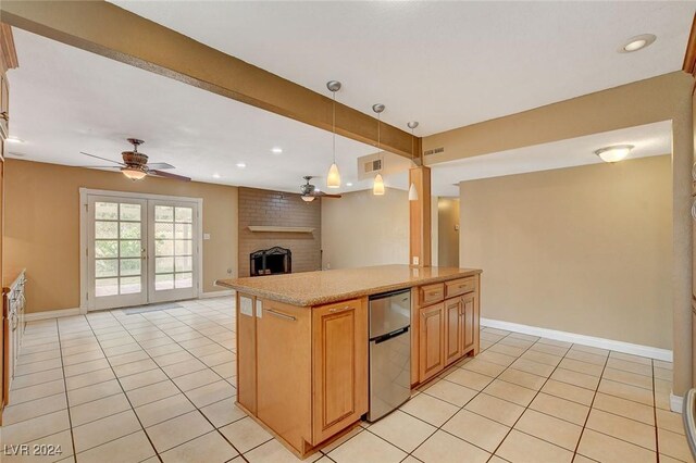 kitchen featuring ceiling fan, french doors, pendant lighting, a fireplace, and light tile patterned floors