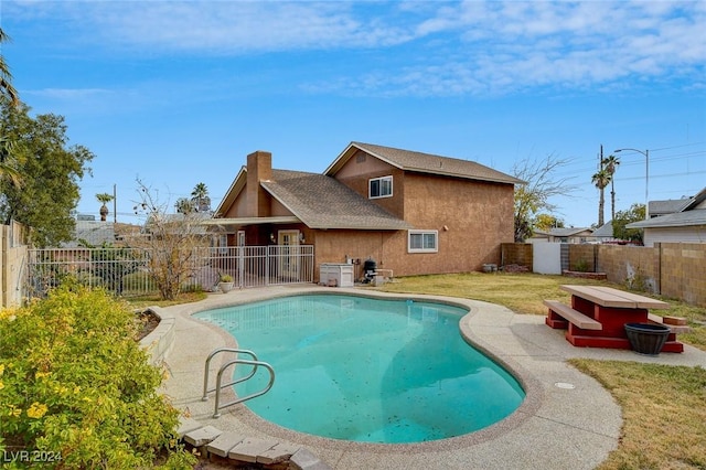 view of swimming pool featuring a yard