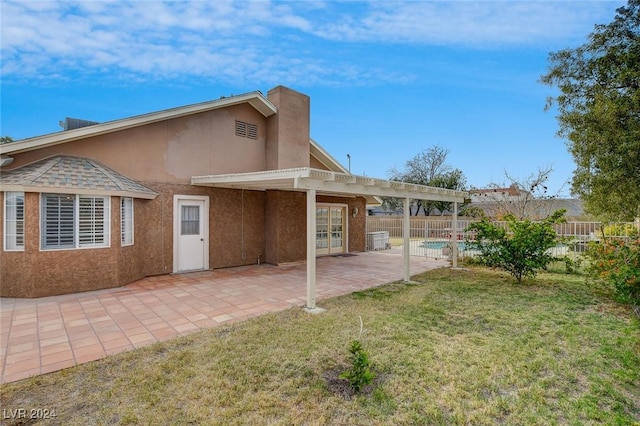 back of house featuring a yard, a patio, and a fenced in pool