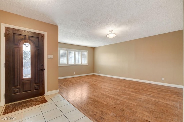 foyer with light hardwood / wood-style floors and a textured ceiling