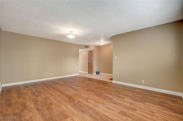 unfurnished room with light hardwood / wood-style floors and a textured ceiling