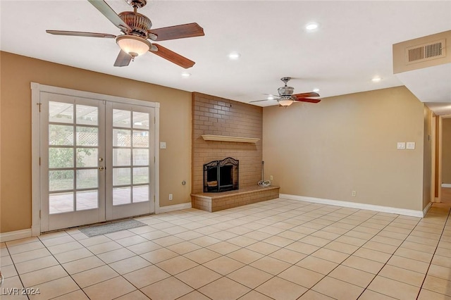 unfurnished living room featuring ceiling fan, light tile patterned floors, a fireplace, and french doors