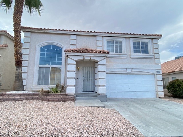 mediterranean / spanish home with a garage