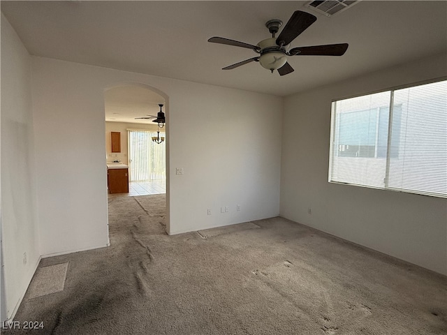 carpeted empty room featuring a healthy amount of sunlight and ceiling fan