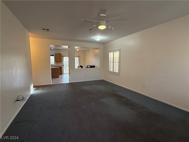 unfurnished living room with light colored carpet and ceiling fan