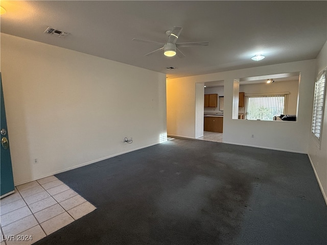 unfurnished living room featuring light colored carpet and ceiling fan