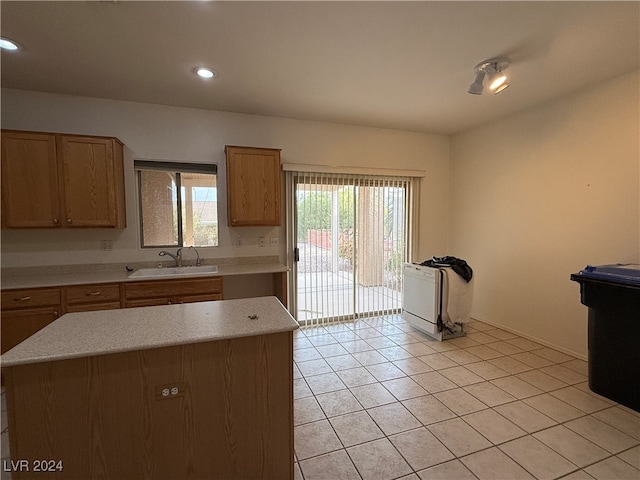 kitchen with a center island, light tile patterned flooring, and sink