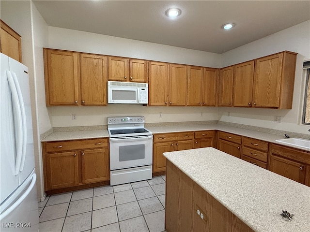 kitchen with sink, light tile patterned floors, and white appliances